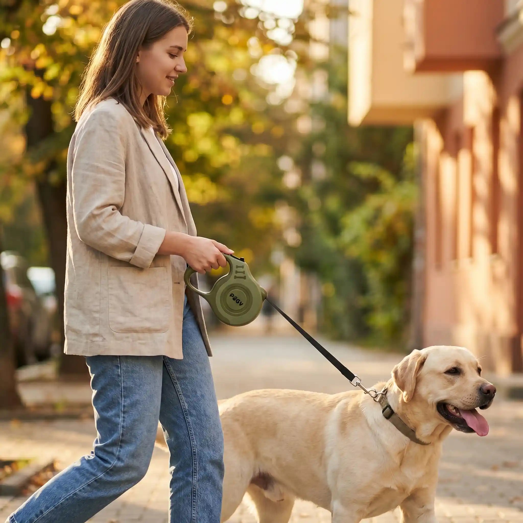 Guia retrátil para cães Pugy — detalhe do botão de travamento e alça ergonômica